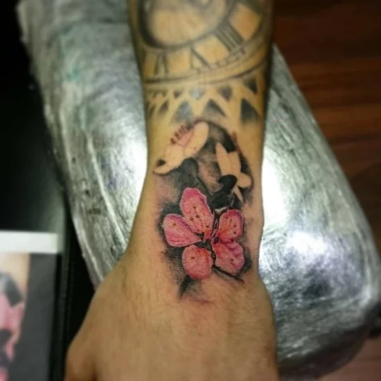 buntes 3D Tattoo am Handgelenk mit Hibiskus-Blüte 