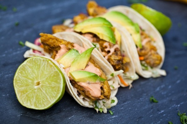 mexikanisches Essen Tacos mit Fisch gefüllt plus Avocado und Zitronenscheiben