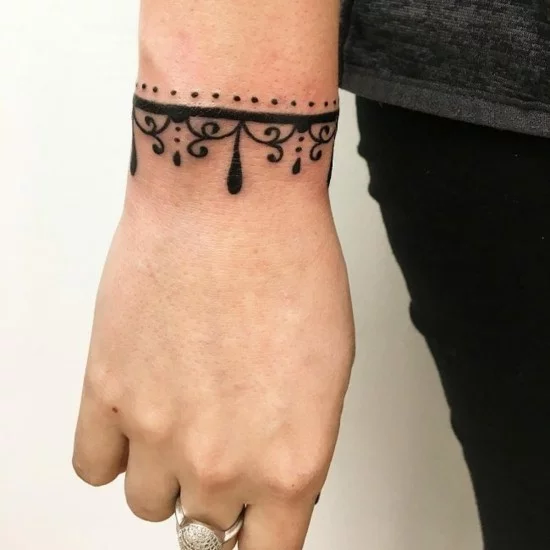 Schmuck-Tattoo am Handgelenk einer Frau