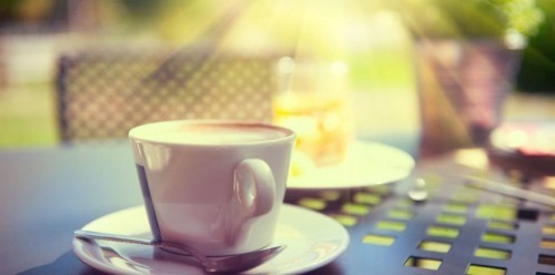 Entspannt eine Tasse aromatischen Kaffee morgens draußen trinken