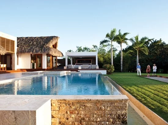 perfekte Outdoor Gestaltung Haus mit Gartenpool grüner Rasen exotische Palmen 
