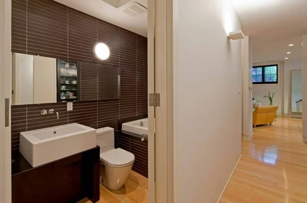 kleines Badezimmer gestalten mit dunkelbraunen Wandfliesen und hellem Boden
