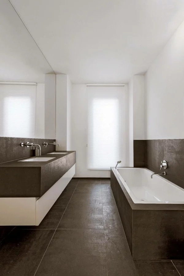 Badezimmer gestalten mit Wänden in Braun-Weiß und einem braunem Boden 