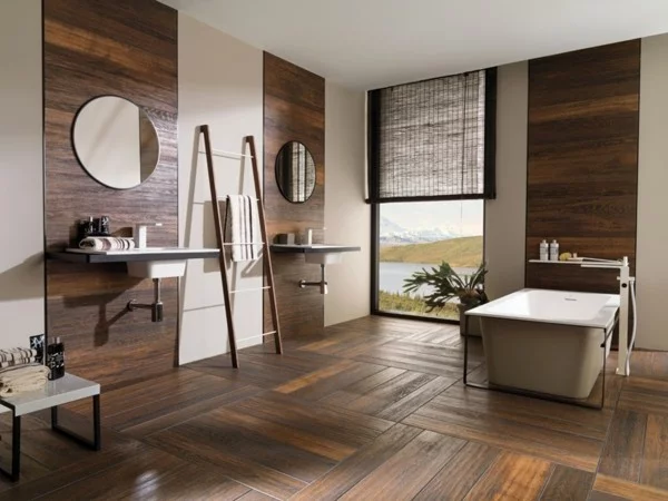 braunes Badezimmer in Holzoptik mit runden Wandspiegeln und freistehender Badewanne