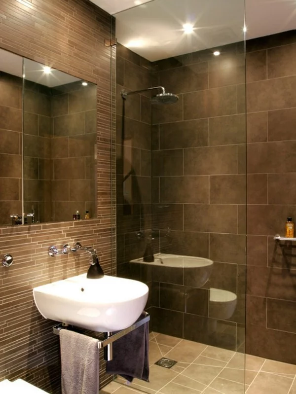 braunes Badezimmer auf kleiner Fläche mit Duschkabine und schöner Deckenbeleuchtung