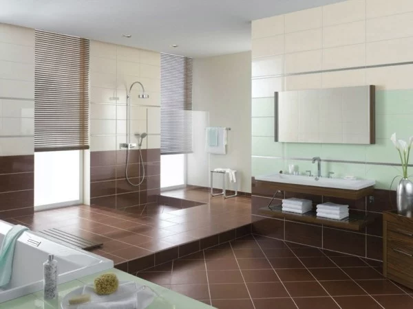 großes Badezimmer mit braunen Bodenfliesen, Fensterverdunkelung und grünen Wandfliesen als Akzent
