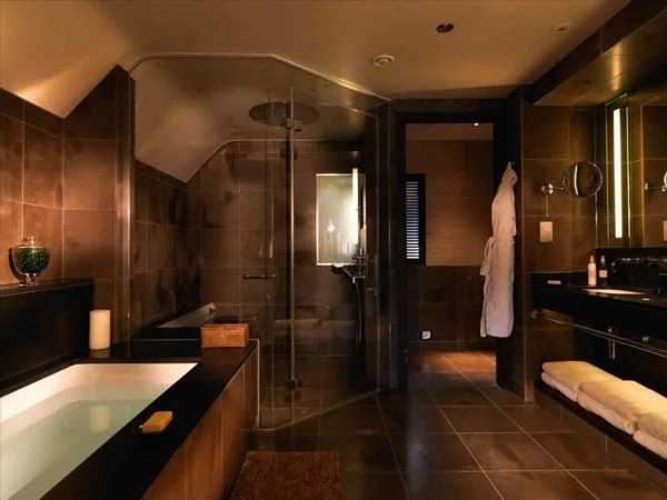braunes Badezimmer in dunklen Tönen mit Badewanne und Duschkabine