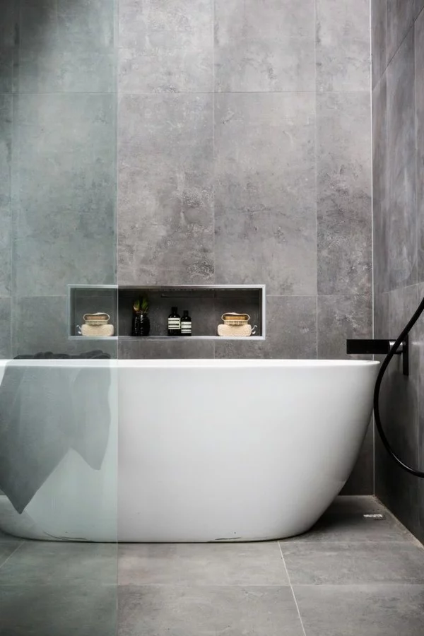 badezimmer grau betonfliesen weiße badewanne