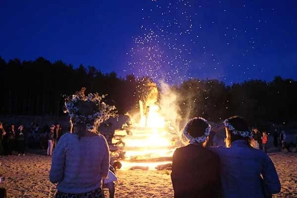 Alte heidnische Tradition Sommersonnenwende feiern Feuer anzünden tanzen spielen herum