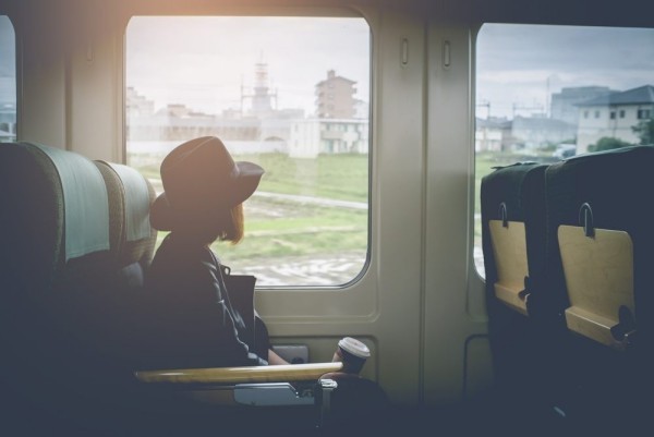 Singlereisen Frau im Zug allein verreisen dem Alltag entfliehen