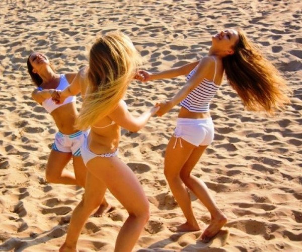 Sommeranfang zelebrieren Sommersonnenwende tanzen am Strand fröhlich sein