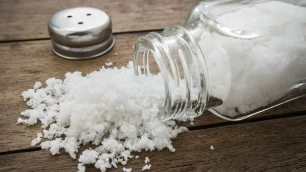 Salz in einen geöffneten Glasfläschchen auf dem Tisch 