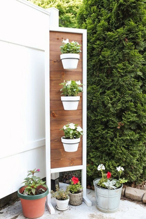 Kleinen Garten gestalten Ständer mit vertikal angeordneten Blumentöpfen in weiß