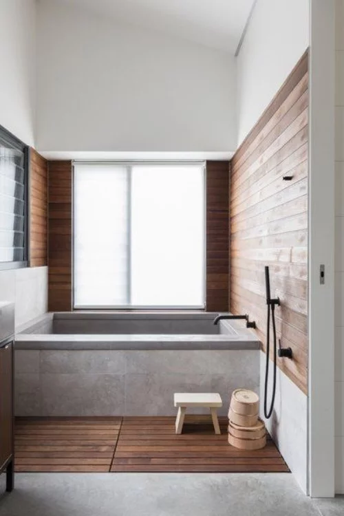 Wandverkleidung Holz im Bad im Einklang mit Holzboden im Kontrast zum Beton