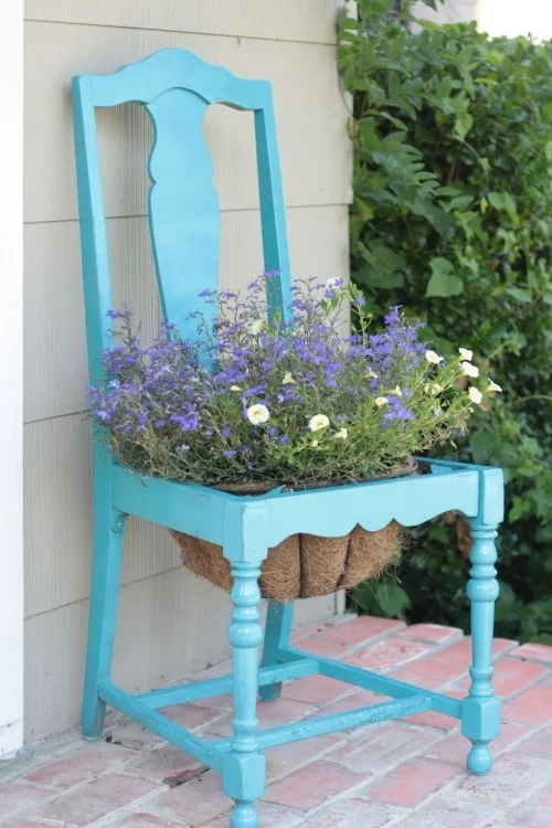 alter Stuhl in blau gestrichen Blumentopf in der Mitte Garten Deko