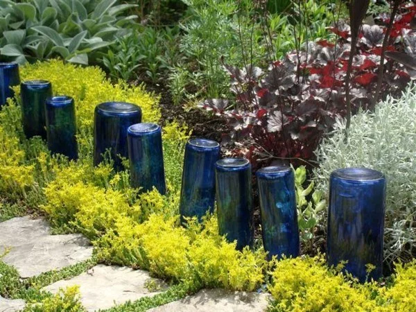DIY Sommerdeko - Beeteinfassung aus leeren, blauen Glasflaschen 