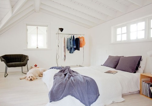weiß gestaltetes Schlafzimmer azurblaue Akzente Dachschräge Kleiderstange
