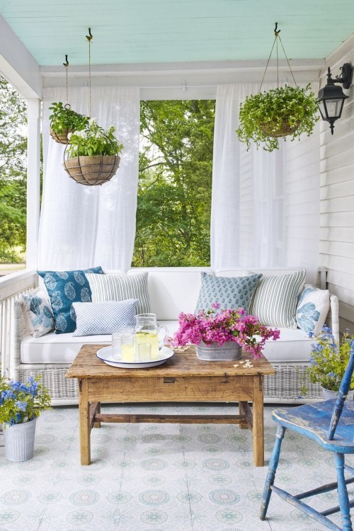 Überdachte Veranda in blau-weiß wie kleinen Garten gestalten Blumenampeln hängen lassen