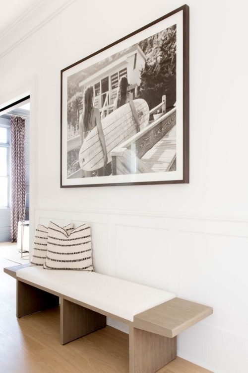 Flur gestalten möglichst simpel aber einladend weiße Wände einfache Sitzbank Deko Kissen Wandbild
