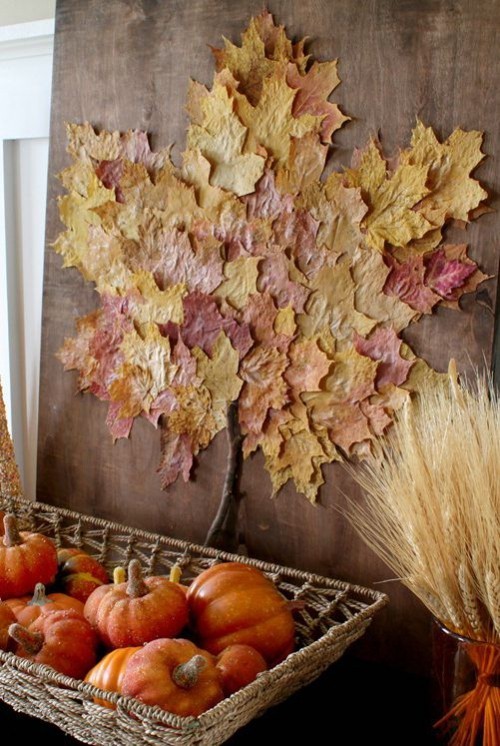 Herbstdeko basteln bunte Herbstblätter an der Wand schön arrangiert Zierkürbisse Weizenstängel darunter