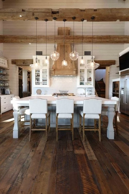 Rustikales Esszimmer im Landhausstil dunkler Holzboden im Kontrast zu weißen Küchenmöbeln 