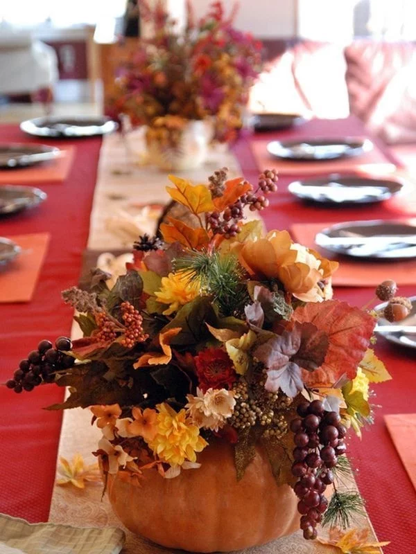 herrliche Tischdeko im Herbst mit Kürbissen, Herbstblumen und -blättern 