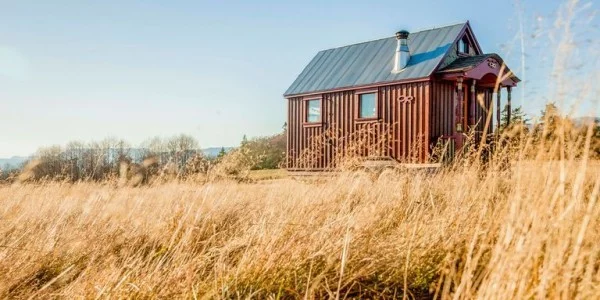 Tiny Houses kleines Haus aus Metall sehr praktisch errichtet im Feld positioniert