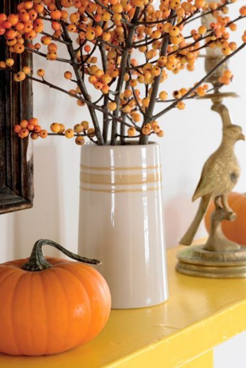 tolle Deko Ideen zu Halloween den Kaminsims dekorieren Kürbis Hagebutten Vogelfigur orange gelb beige
