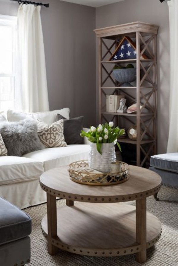 Wohnaccessoires im modernen Wohnzimmer runder Tisch weiße Tulpen in Vase offenes Regal