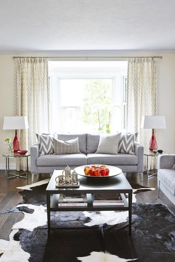 Wohnaccessoires im modernen Wohnzimmer schönes Ambiente Fellteppich grau schwarz Sofa Lampen