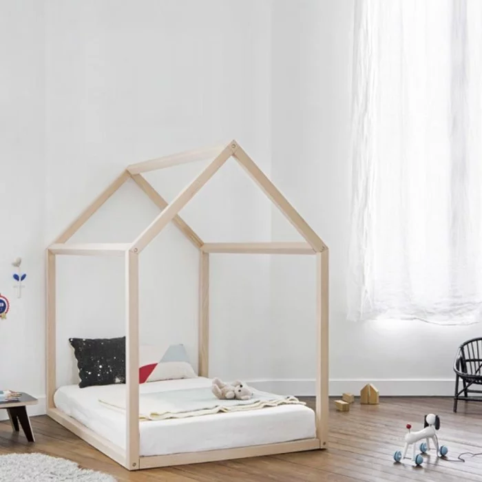 kleines Haus aus Holz kombiniert mit dem Montessori Bett in einem hellen Kinderzimmer 