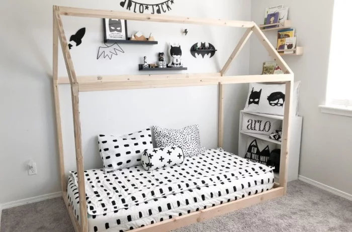 Montessori Bett mit Holzrahmen und schön gemusterter Bettwäsche und Deko 