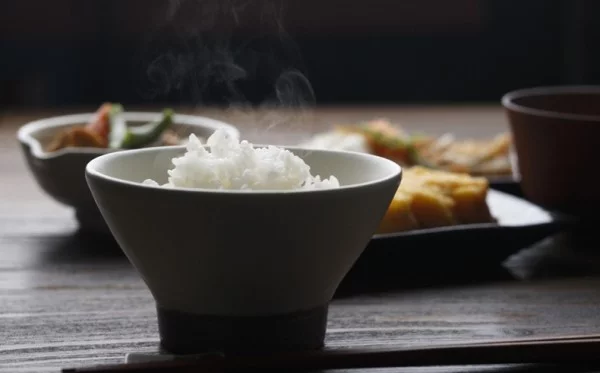 Japanisches Essen Reis wird gedämpft in Schüssel serviert gesunde Lebensweise