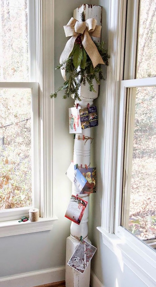 Weihnachtskarten an einer Holzsäule anbringen Tannengrün und Schleife dazu