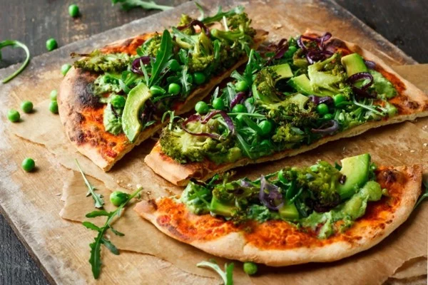 grüner Pizzabelag mit grünen Erbsen, Brokkoli und Avocado 