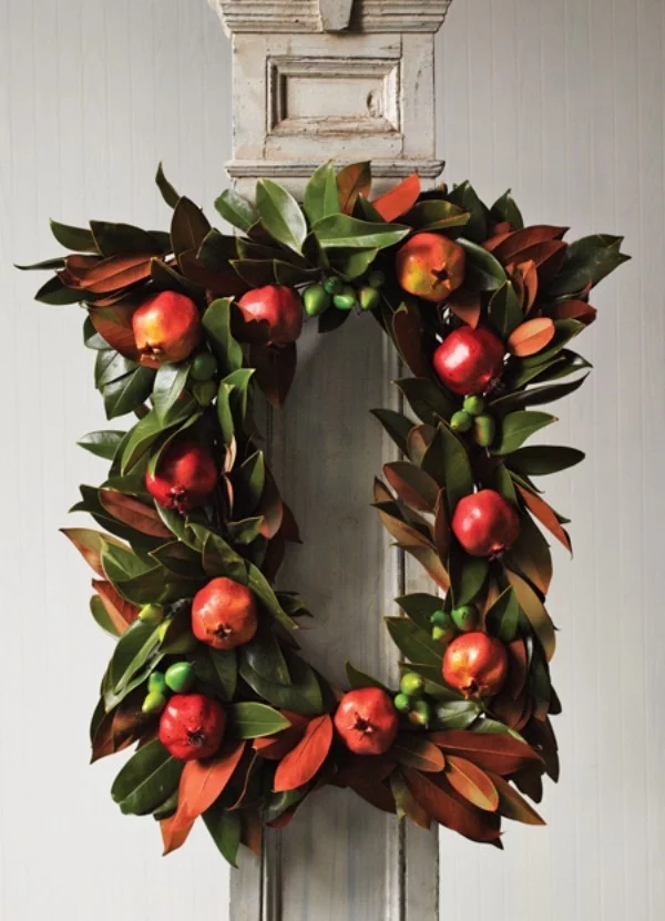 Weihnachtskranz aus Magnolienzweigen mit Granatäpfeln geschmückt