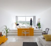 Minimalistisch eingerichtete kleine Wohnung fällt durch gelbe Akzente auf