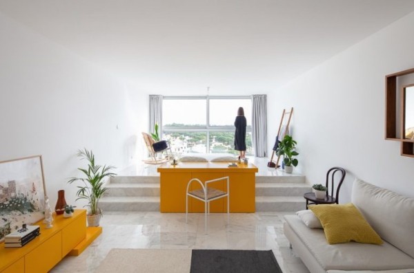 Kleine Wohnung minimalistisch eingerichtet gelbe Akzente Grünpflanzen