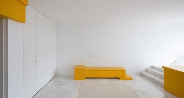 Kleine Wohnung minimalistisches Raumkonzept wenige Möbel gelbe Akzente