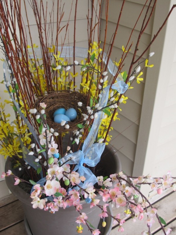 Osterdeko draußen Eimer mit blühenden zweigen Nest mit blau gefärbten Eiern