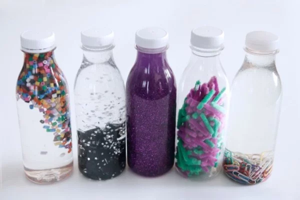 Kinderspielzeuge selber machen DIY Sensorik Flaschen unterschiedliche Füllung in verschiedenen Farben 