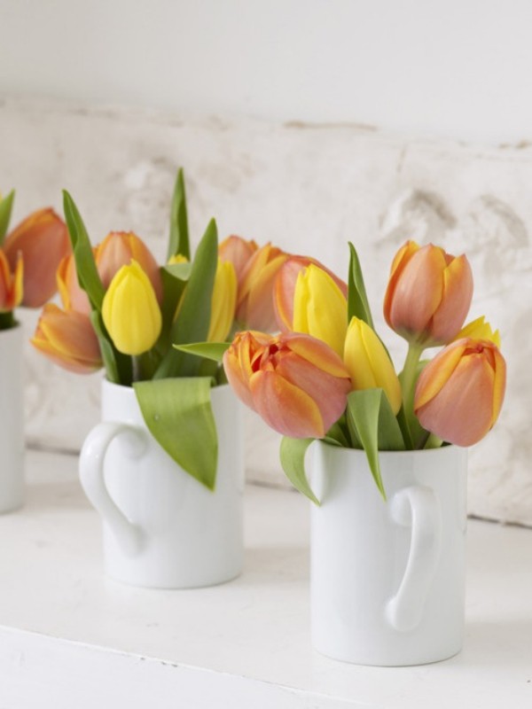 Tulpen im Interieur mehrfarbige Blüten in Porzellanbechern