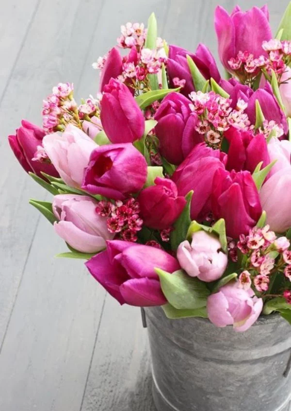 Tulpen im Interieur rosa und violett mit anderen kleinen Blüten kombiniert