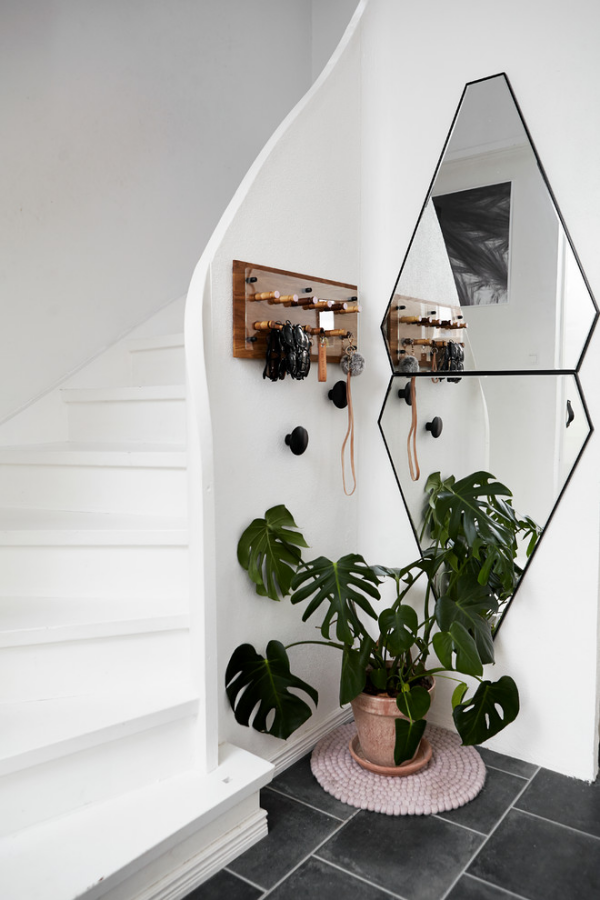 Dekorative Wandspiegel im Flur Treppenhaus weißes Design ausgefallene Spiegelform frische Grünpflanze