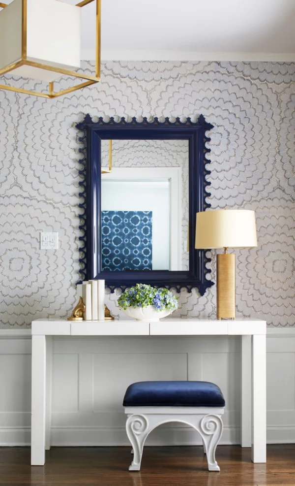 Dekorative Wandspiegel im Flur rechteckige Form dunkelblauer Rahmen Hocker Tisch