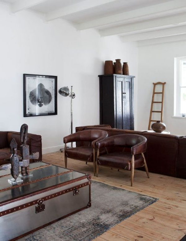 Maskulin und elegant modernes Wohnzimmer natürliche einfache Einrichtung zwei Ledersessel viel Licht Deko Figuren