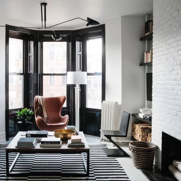 Maskulin und elegant modernes Wohnzimmer weiß gestrichene Ziegelwand Egg Chair aus Leder als Akzent