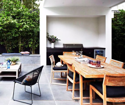 Outdoor Küche in Schwarz gestaltet klein unter Dach langer Esstisch viele Stühle