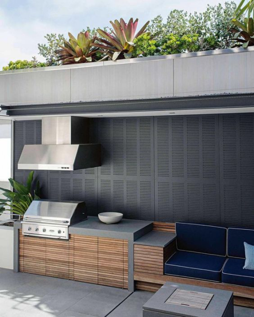Outdoor Küche modern eingerichtet und gestaltet Grillgerät Abzugshaube Edelstahl Beton Teakholz