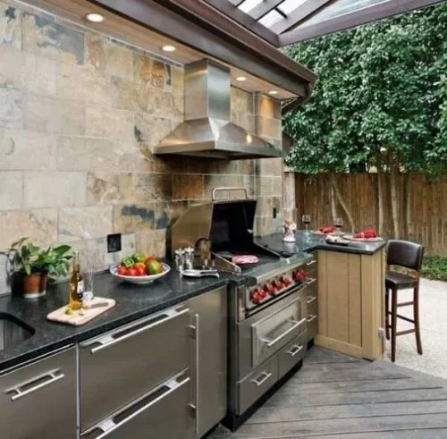 Outdoor Küche voll ausgestattet Steinwand moderne eingebaute Küchengeräte Abzugshaube